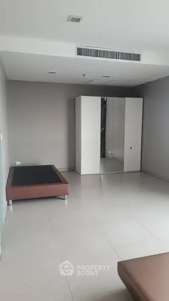 Spacious minimalist bedroom with modern wardrobe and sleek design.