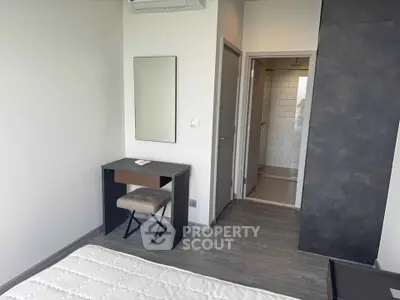 Modern bedroom with minimalist furniture and ensuite bathroom in a stylish apartment.