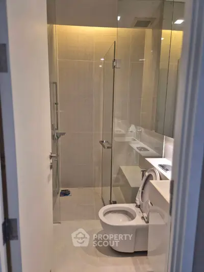 Modern bathroom with glass shower and sleek fixtures in a contemporary apartment.