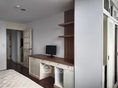 Spacious bedroom with built-in desk and ample storage space