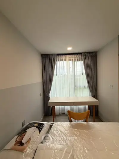 Cozy bedroom with natural light and modern furnishings, perfect for relaxation and productivity.