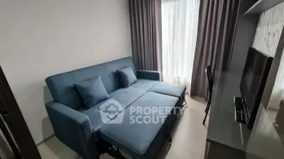 Modern living room with stylish blue sofa and sleek TV setup