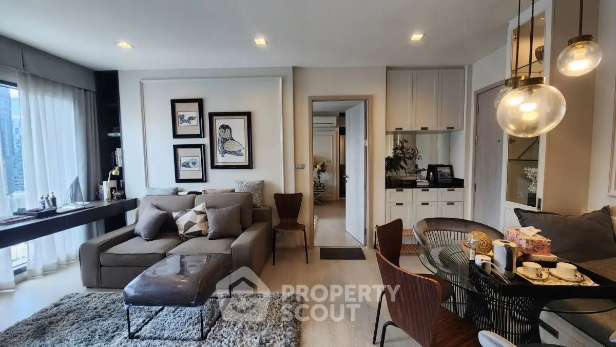 Modern living room with stylish decor and large windows offering city views.