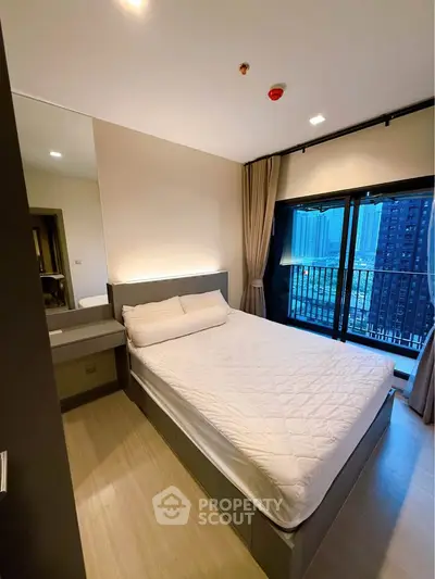 Modern bedroom with city view and large windows in a high-rise apartment.