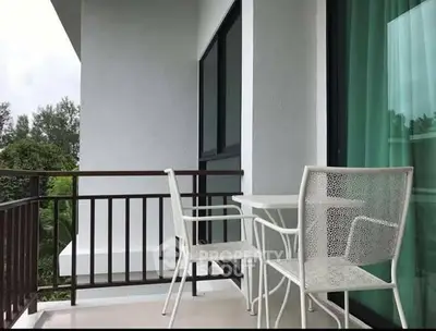 Charming balcony with modern white furniture and lush green view, perfect for relaxation.