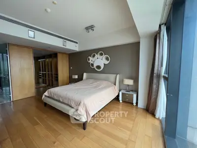 Spacious modern bedroom with wooden flooring and stylish decor