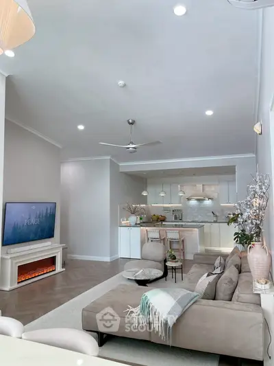 Modern living room with open kitchen, cozy fireplace, and elegant decor in a stylish apartment.