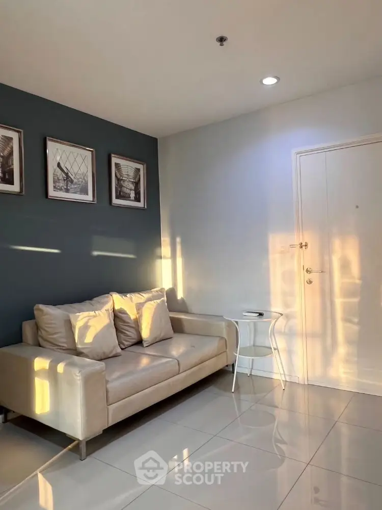Cozy living room with modern sofa and stylish decor, bathed in warm natural light.