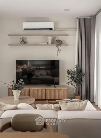 Modern living room with sleek furniture, large TV, and elegant decor, perfect for stylish urban living.