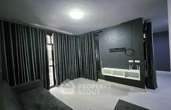 Modern living room with dark curtains and sleek TV mount