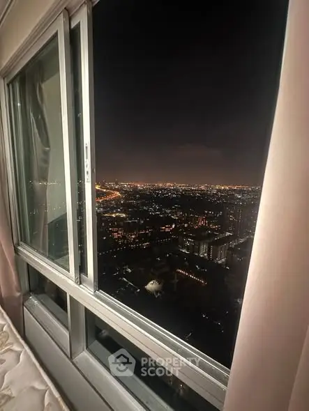 Stunning cityscape view from high-rise apartment window at night.