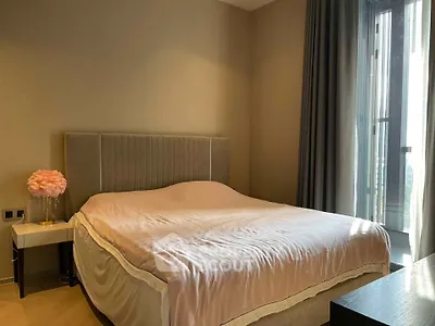 Luxurious bedroom with elegant decor and large window offering natural light.