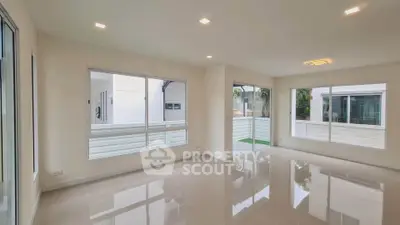 Spacious modern living room with large windows and glossy tiled floors