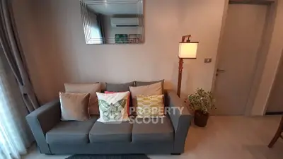 Stylish living room with modern sofa, decorative pillows, and elegant lighting.