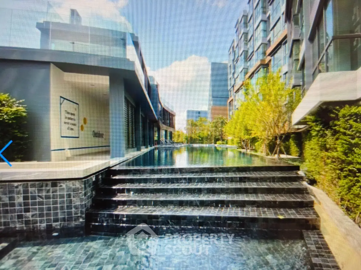 Luxurious modern apartment complex with stunning pool and lush greenery