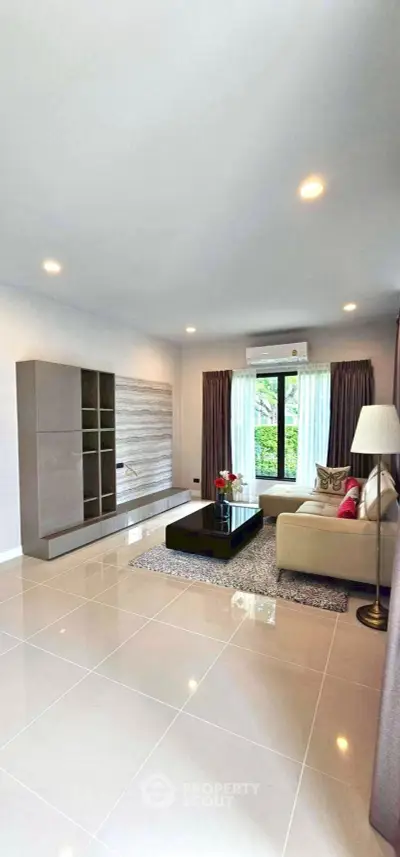 Spacious modern living room with elegant decor and large windows for natural light.