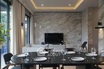 Elegant living room with marble wall, modern dining setup, and large windows for natural light.