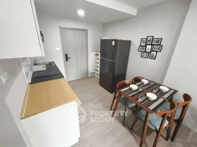 Modern kitchen with dining area, featuring sleek appliances and stylish decor.