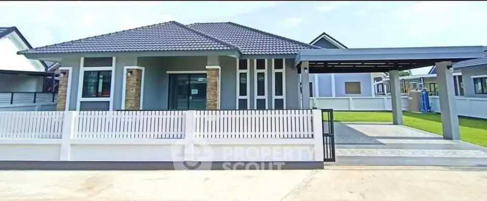 Modern single-story house with sleek design and spacious driveway in a serene neighborhood.