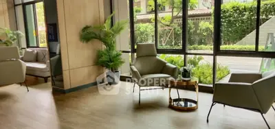 Modern living room with large windows and stylish furniture, offering a serene garden view.
