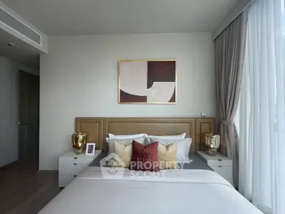 Luxurious bedroom with modern decor and large window offering natural light.