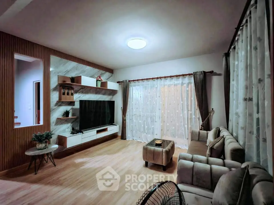 Stylish living room with modern decor, large TV, and cozy seating area.
