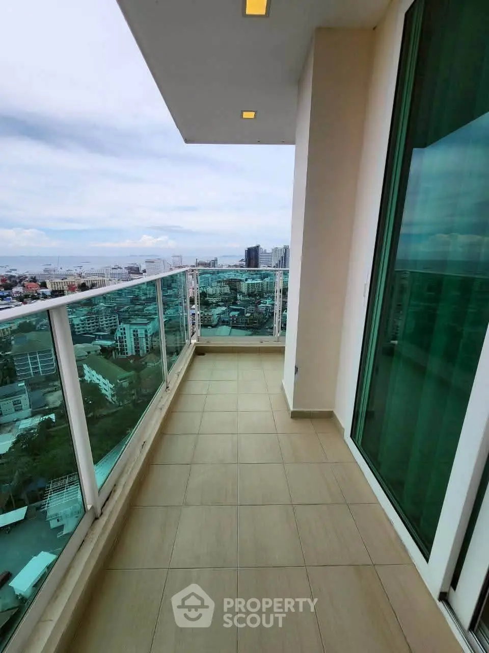 Stunning high-rise balcony with panoramic city views and modern glass railing.