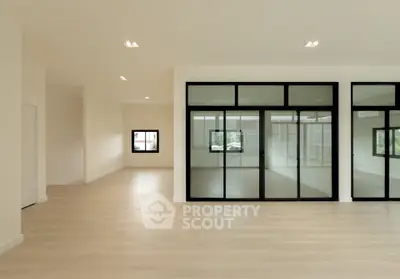 Spacious modern interior with large windows and light wood flooring