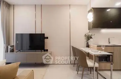 Modern living room with sleek TV setup and elegant dining area in open kitchen layout.