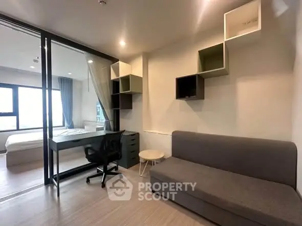 Modern studio apartment with stylish furniture and glass partitioned bedroom.