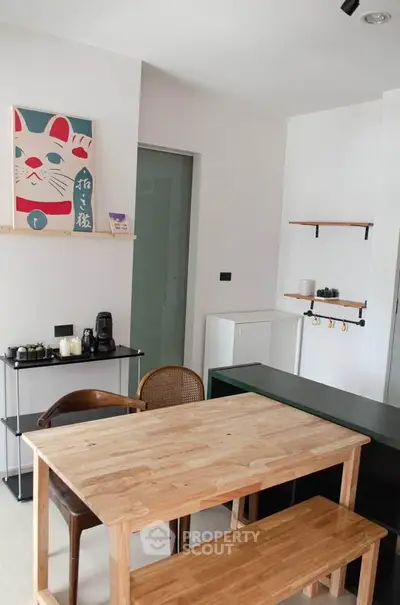 Charming dining area with wooden table and chairs, modern decor, and stylish shelving in a cozy apartment.