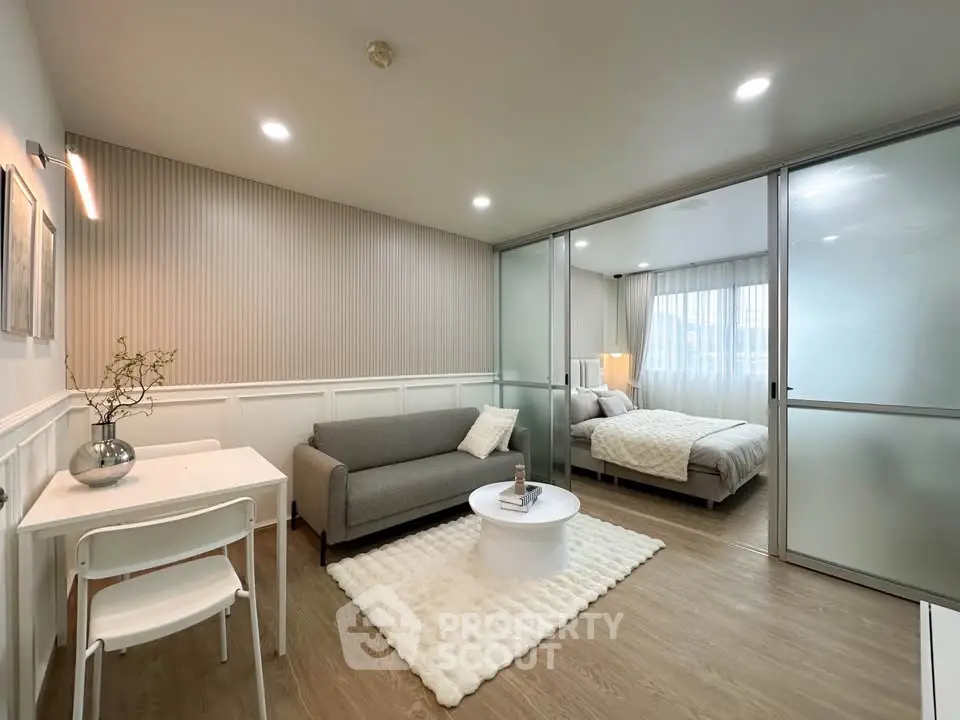 Modern studio apartment with open living area and cozy bedroom, featuring stylish decor and natural light.