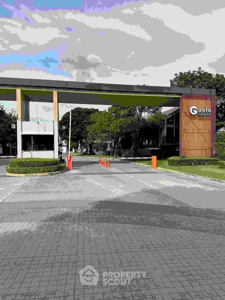Modern gated entrance with lush greenery and secure access.