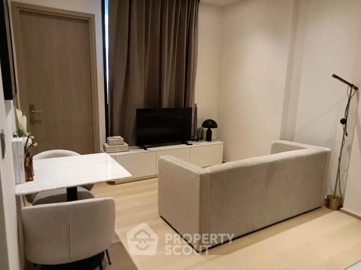 Modern living room with cozy sofa, TV, and stylish decor in a compact space.