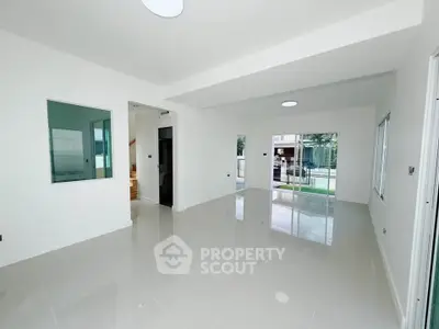 Spacious modern living room with glossy tiled floors and large windows for natural light.