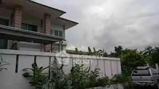 Modern two-story house with lush garden and driveway