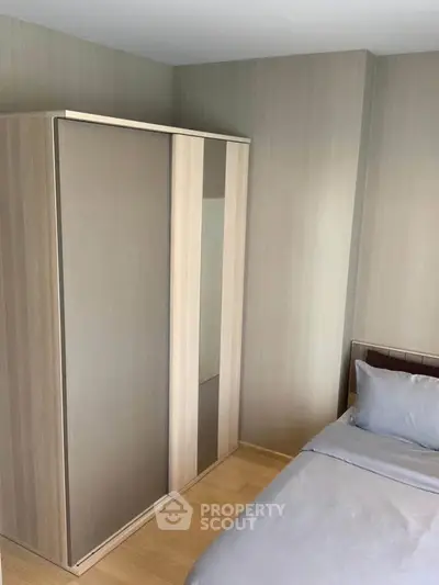 Cozy bedroom with modern wardrobe and comfortable bedding, perfect for restful nights.