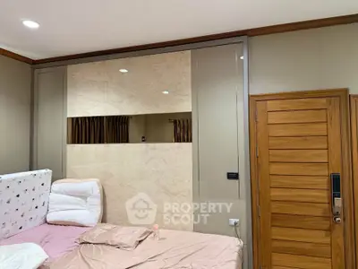Cozy bedroom with modern design and wooden accents, featuring a comfortable bed and stylish decor.