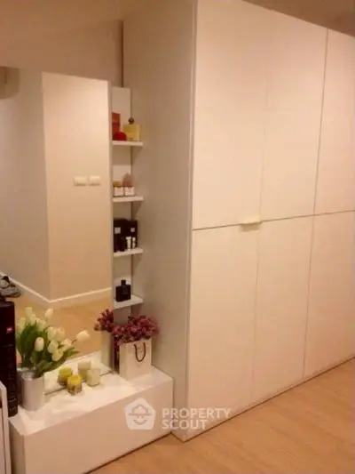 Modern minimalist storage space with sleek white cabinets and decorative accents.