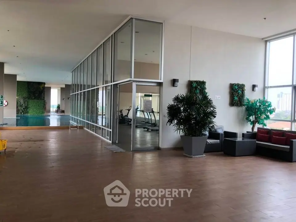 Luxurious indoor pool area with modern gym and seating, perfect for relaxation and fitness.