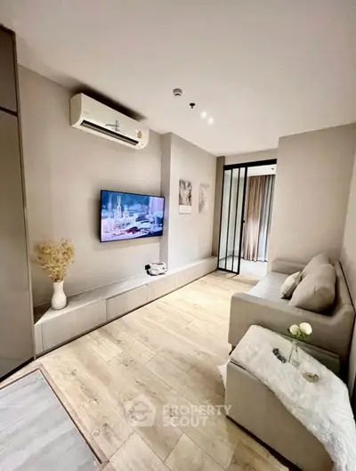 Modern living room with sleek design, featuring a wall-mounted TV and cozy seating area.