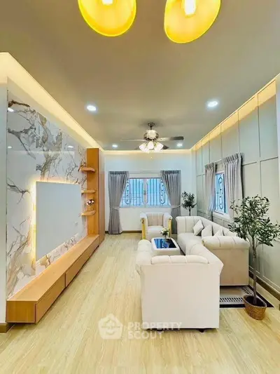 Elegant living room with modern decor, marble accent wall, and cozy seating area.