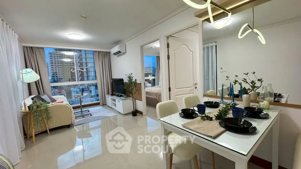 Modern open-plan living room and dining area with city view, stylish decor, and natural light.
