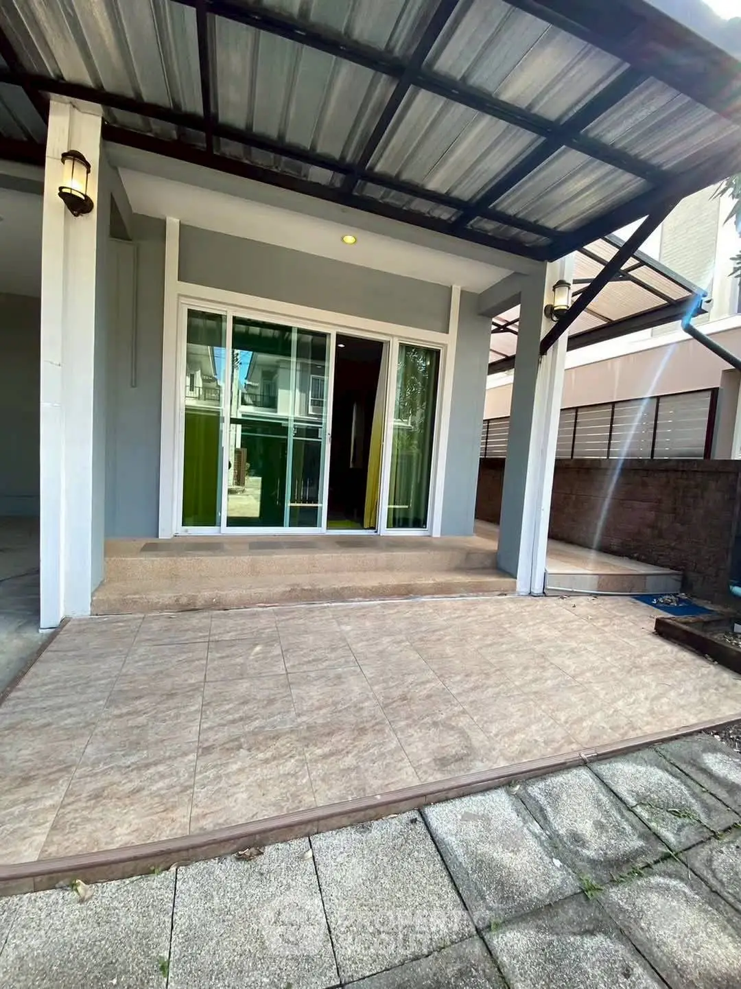 Charming home entrance with covered patio and sliding glass doors, perfect for welcoming guests.
