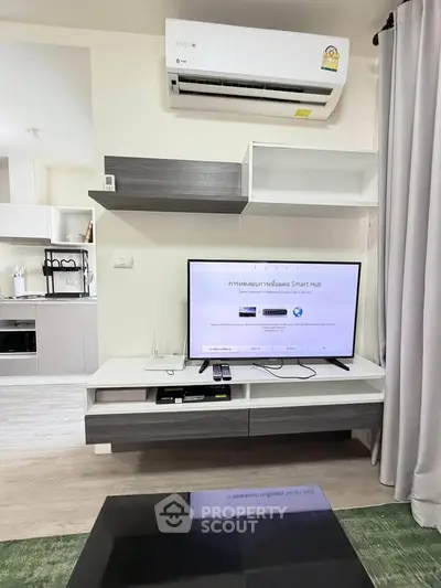 Modern living room with sleek TV setup and stylish shelving, featuring a contemporary air conditioning unit.