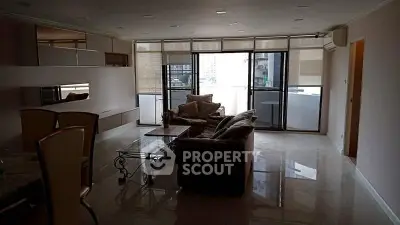 Spacious living room with modern furniture and large windows offering city views.