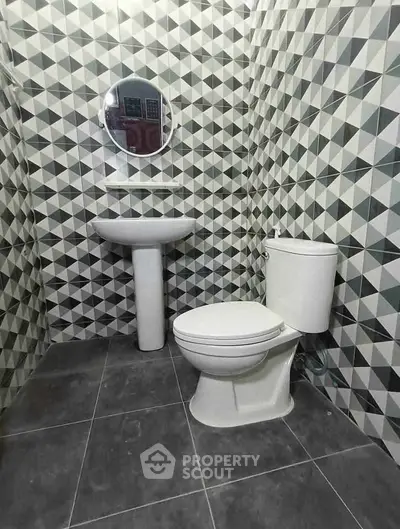 Modern bathroom with geometric tile design and sleek fixtures.