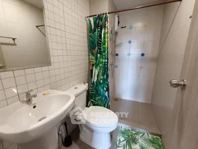 Modern bathroom with tropical-themed decor and walk-in shower