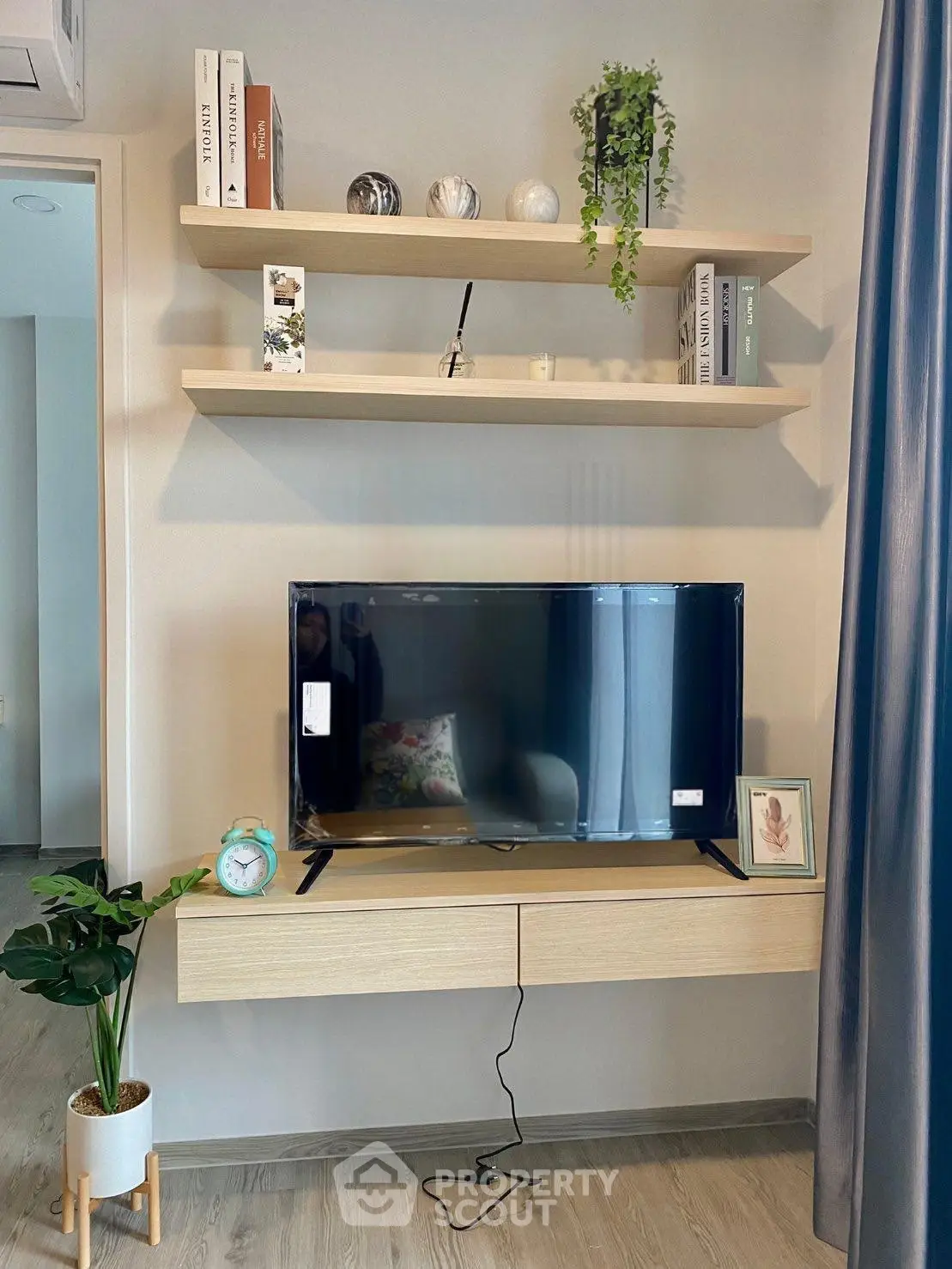 Modern living room with sleek TV stand and floating shelves, perfect for stylish urban living.
