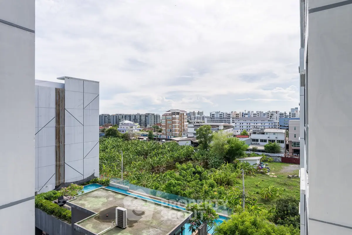 Stunning urban view from high-rise building with lush greenery and modern architecture.